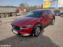Red Mazda CX-30 parked on a gravel lot.