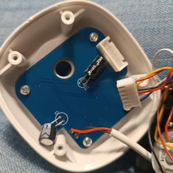 Close-up of an open electronic device mechanism showing a circuit board and wires.