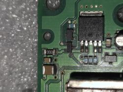 Close-up of a green PCB with an IC and SMD components, photographed on bubble wrap
