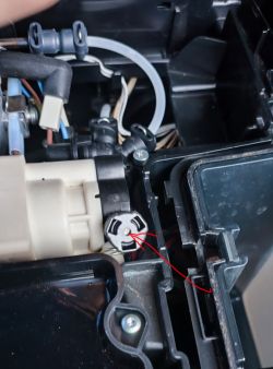 Inside of a coffee machine with a marked hole and replaced valve.