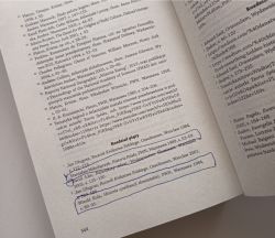 Book page with footnotes and handwritten pen markings near the bottom