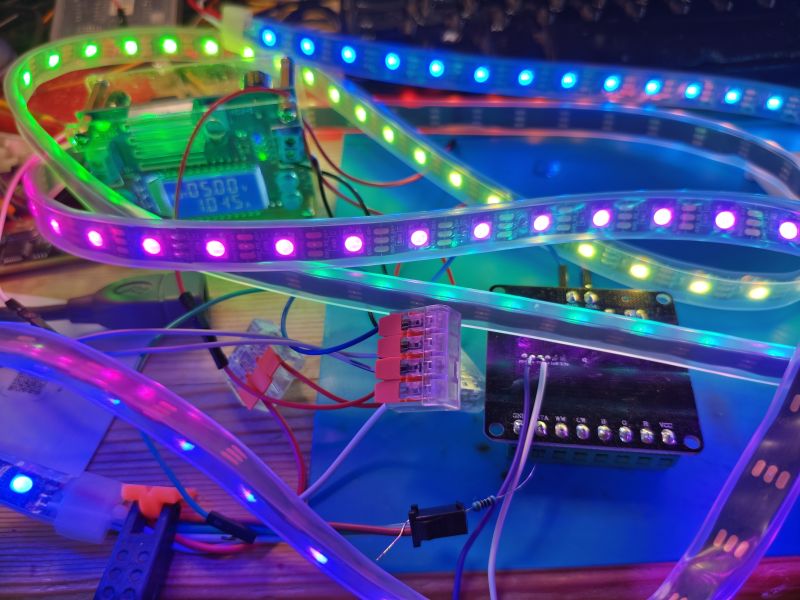 Colorful SPI LED strip connected to microcontroller with wires on a desk