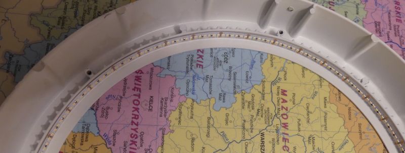 Białe okrągłe urządzenie z pierścieniem diod LED leży na mapie Polski