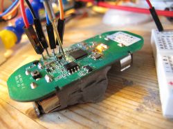 Close-up of a circuit board with several wires connected to terminals, with an LED lit nearby.