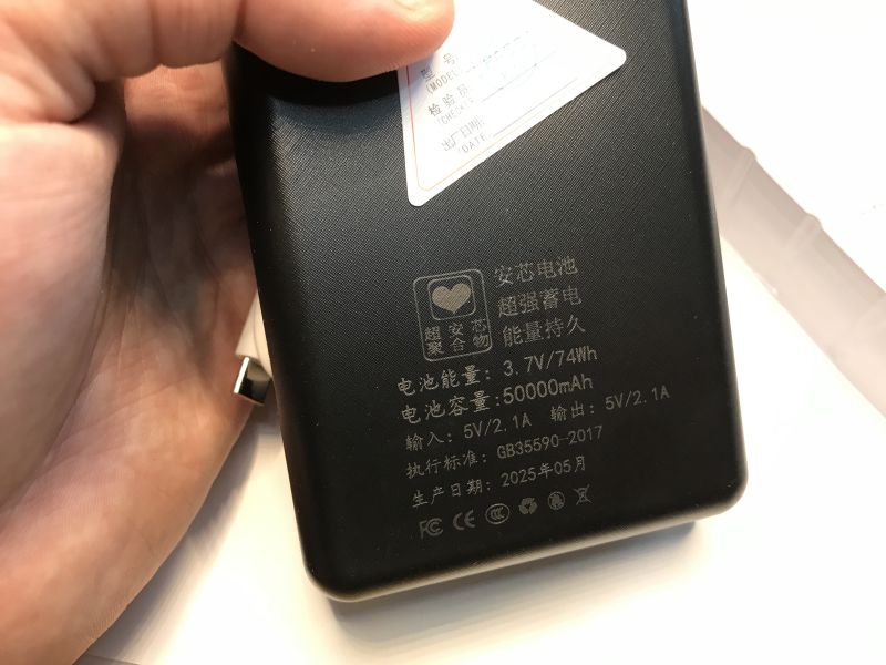 Close-up of the back of a black power bank with Chinese text: 3.7V/74Wh, 50000mAh, 5V/2.1A