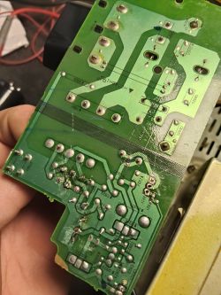 Spód płytki PCB z widocznymi ścieżkami, polami lutowniczymi i śladami przypaleń