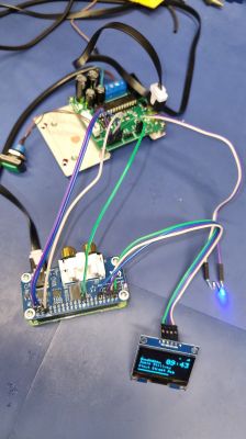 Test setup with PCB, OLED display, and blue LED connection Connected PCB board with wires, OLED display, and glowing blue LED