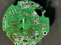 Zielona płytka PCB z punktami lutowniczymi i elementami SMD na czarnym tle