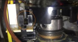 Zbliżenie na mechanizm z zaznaczonym czujnikiem i plastikową nakładką na wał.