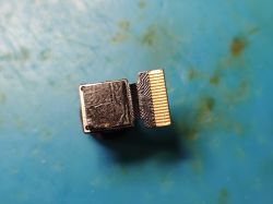 Camera module with flexible ribbon and connector on a blue surface