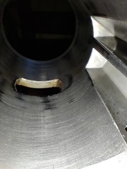 Wnętrze cylindra silnika dwusuwowego z widocznymi rysami i kanałem przepływowym