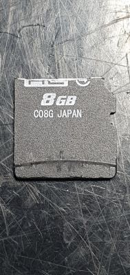 Karta pamięci 8 GB z napisem C08G JAPAN na ciemnym tle.