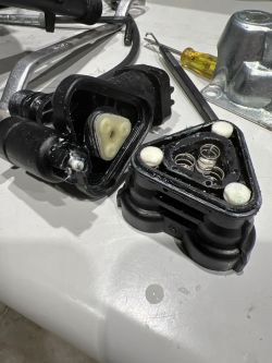The image shows disassembled parts of a plastic pressure head with visible springs.