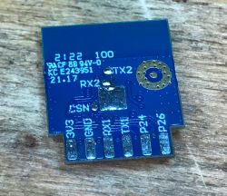 Close-up of a Tuya CB2S module with exposed shielding and visible soldering pads.
