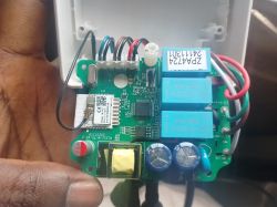 Close-up view of a circuit board inside an electronic device with visible relays, components, and wires.