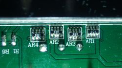 Nahaufnahme einer grünen Leiterplatte mit elektronischen Bauteilen, die als AR1, AR2, AR3 und AR4 beschriftet sind.