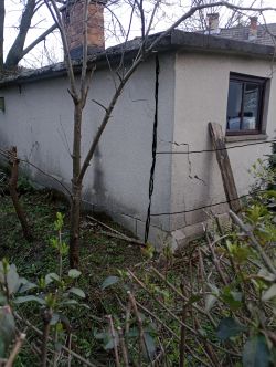 Ściana garażu z widocznymi dużymi pęknięciami.