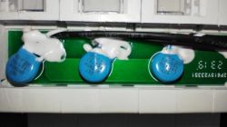 Three blue varistors mounted on a green PCB, with a wire above and white glue securing the components.