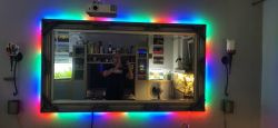 Mirror with colorful LED backlighting on the wall.
