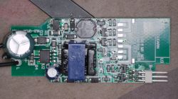 Close-up of a green controller PCB with capacitors, inductor, SMD parts, and a 3-pin connector