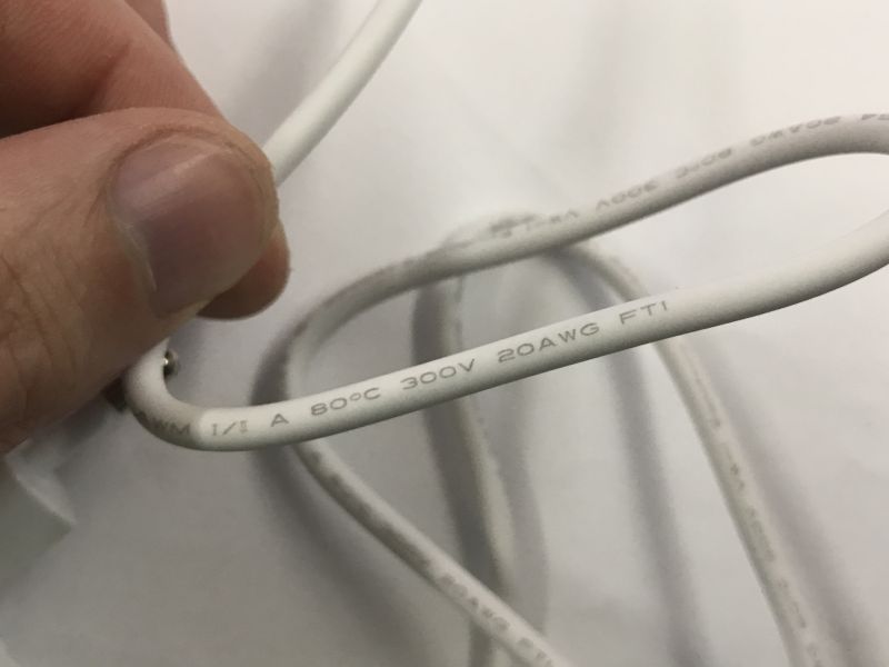 Zbliżenie na biały przewód z oznaczeniami technicznymi 20AWG, 300V, 80°C