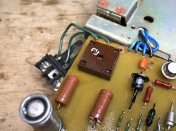 Close-up of a PCB with components, wires, and part of a metal device enclosure