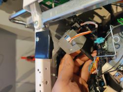 Ręka trzymająca złącze elektryczne w środku urządzenia.