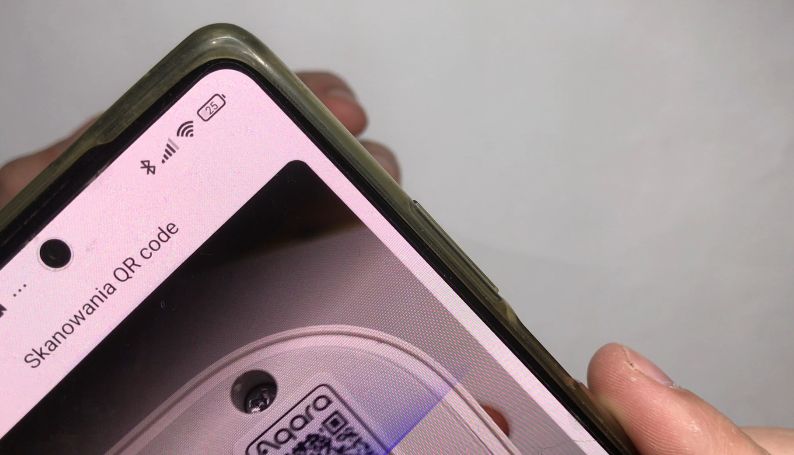 Zbliżenie telefonu skanującego kod QR na urządzeniu z napisem Skanowania QR code