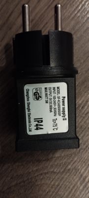 Widok zasilacza elektrycznego z etykietą informacyjną.