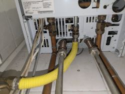 Zawory i rury pieca Vaillant atmoTEC plus pokazane z tyłu urządzenia.