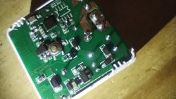 Close-up of a circuit board with various electronic components like resistors and integrated circuits on a wooden background.