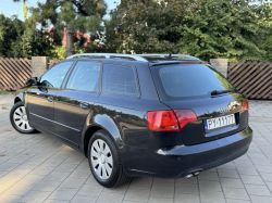 Black Audi A4 station wagon parked on a driveway, rear left side view.