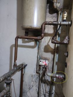 Zawór i instalacja hydrauliczna przy bojlerze w pomieszczeniu technicznym