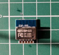 ESP-02S module on a green cutting mat.