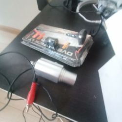 Kamera z kablem RCA i opakowaniem na ciemnym blacie.