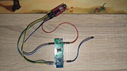 Electronic modules connected with wires on a wooden surface.