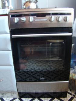 Kuchenka gazowa marki Amica z piekarnikiem i pokrętłami na panelu przednim.