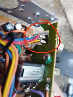 Zbliżenie na uszkodzenie płytki radia CB Magnum MX z widocznymi kolorowymi przewodami.