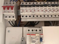 Zbliżenie na panel elektryczny z różnymi wyłącznikami automatycznymi, w tym wyłączniki nadprądowe marki Eaton.
