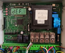 Zdjęcie wnętrza centrali elektronicznej z wyświetlaczem i komponentami elektronicznymi.