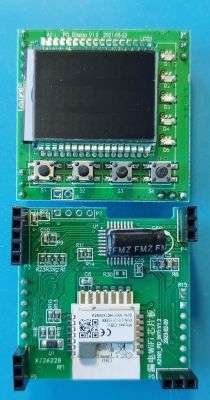 Two green printed circuit boards with a display and buttons.