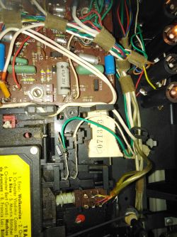 Wnętrze urządzenia z widocznymi płytkami elektronicznymi i okablowaniem.
