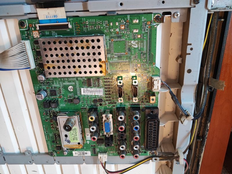 Interior of a Flood-Damaged Samsung TV Flood-damaged Samsung LE32A330J1N TV with visible dirt on the circuit board.