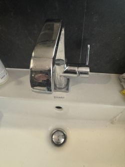 Chromowana bateria umywalkowa zamontowana na umywalce Duravit.