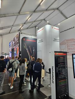 Stoisko HELUKABEL z przewodami i kablami, odwiedzający rozmawiają z przedstawicielami