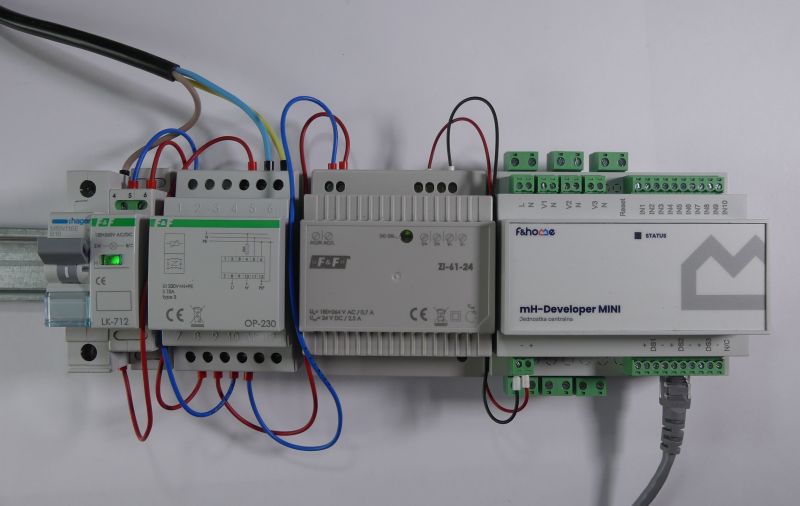 Sterowniki elektryczne na szynie DIN z podłączonymi przewodami i urządzeniem mH-Developer MINI