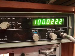 Wyświetlacz urządzenia pomiarowego pokazujący częstotliwość 100.0222 MHz