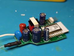 Płytka elektroniki z kondensatorami, przewodem i modułem radiowym na niebieskiej macie