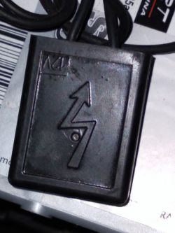 Czarny, plastikowy moduł z symbolem błyskawicy i grotu skierowanego ku górze, podłączony do akumulatora w Citroenie C3 Picasso.