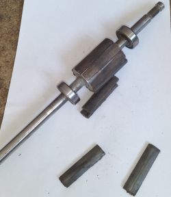 Rotor with detached magnets lying on a white surface.
